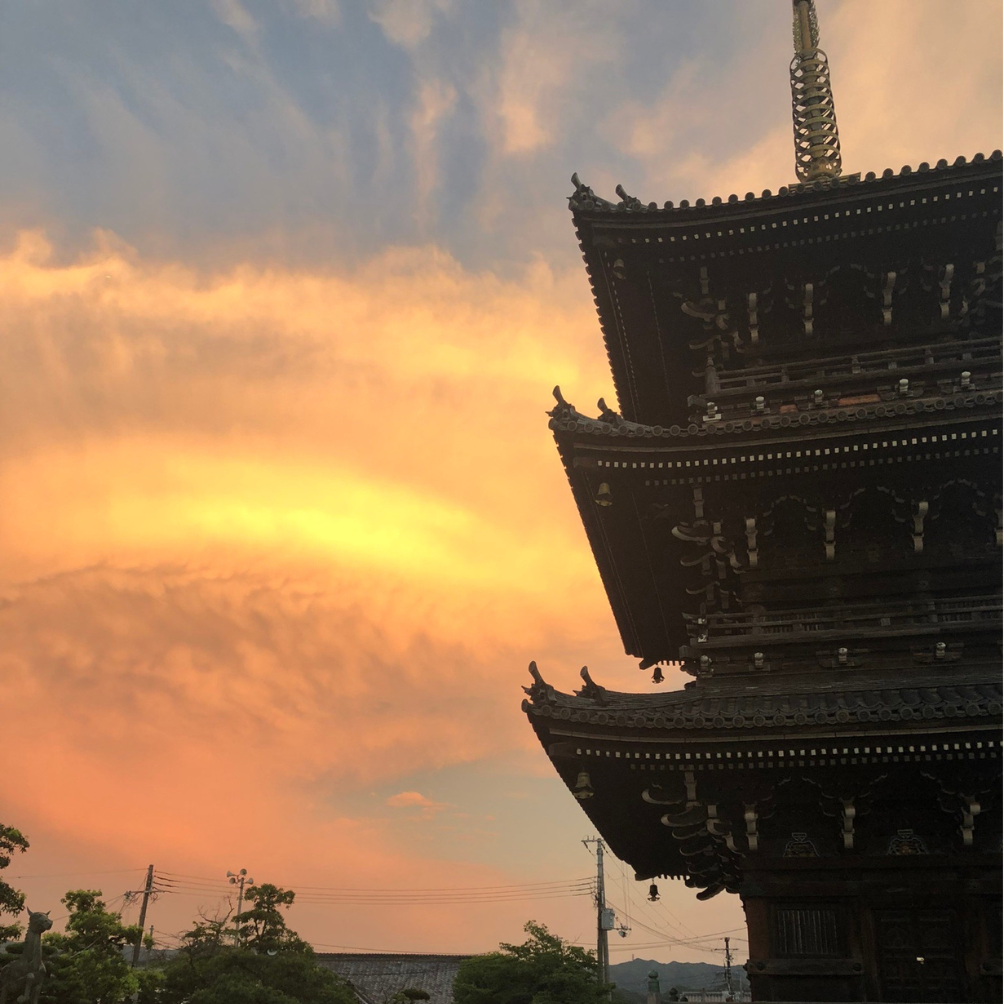 夕焼けに染まる空を背景にした水間寺の三重塔
